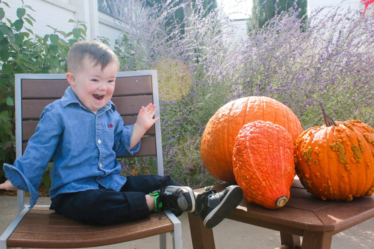 Special needs boy looking at pumpkins